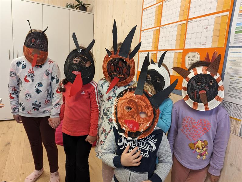 Kinder mit selbst gebastelten Krampusmasken